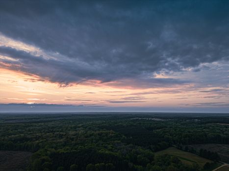A breathtaking aerial view of a lush forest landscape under a vibrant sunset sky in Haw Branch, VA.