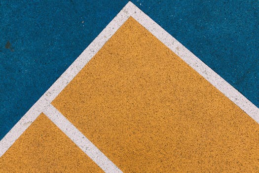 Closeup of a colorful geometric pattern on a sports court with lines and vibrant colors.
