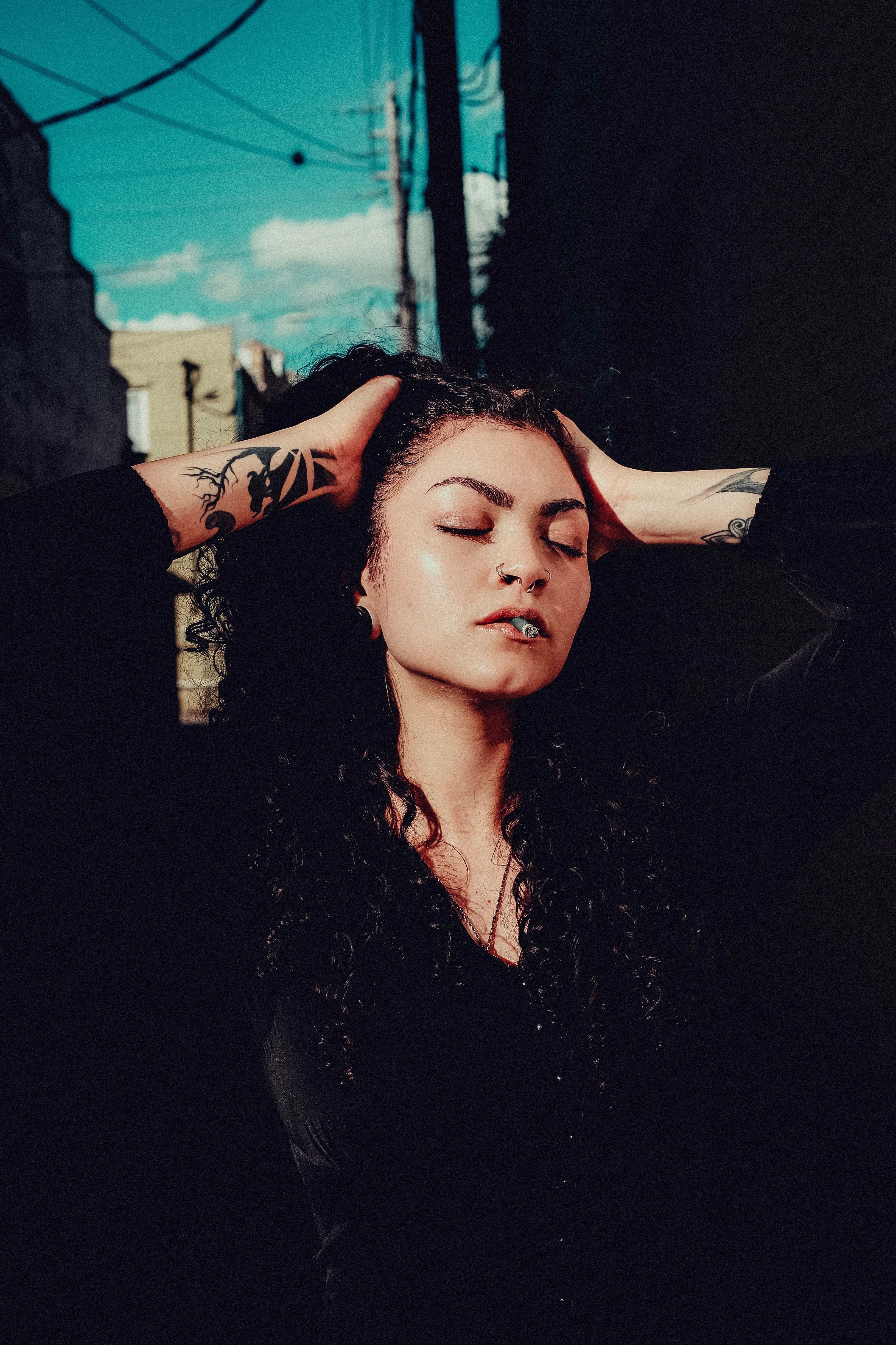 A woman with tattoos on her head and hands on her head · Free Stock Photo