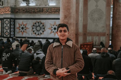 A young man standing in a mosque