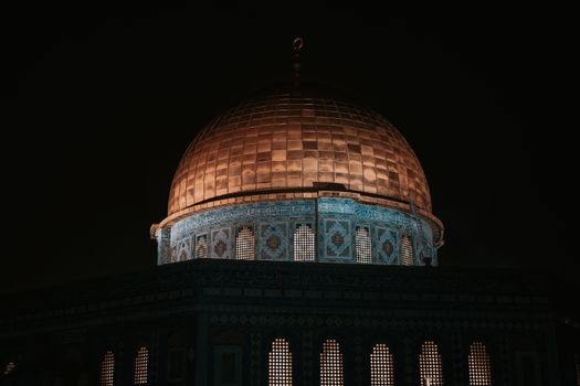 The Dome of the Rock beautifully illuminated under a night sky in Jerusalem.
