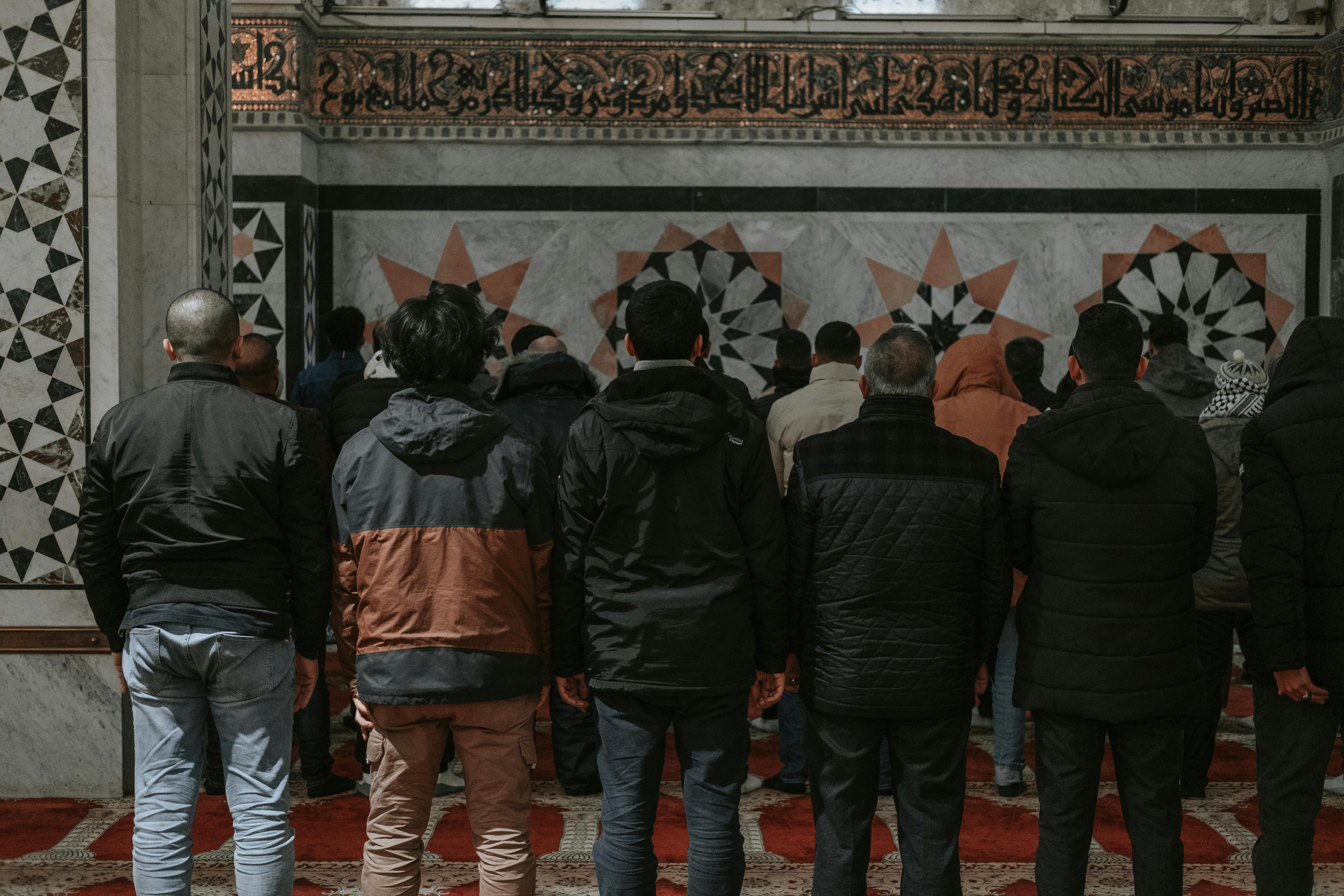 a group of people standing in a mosque