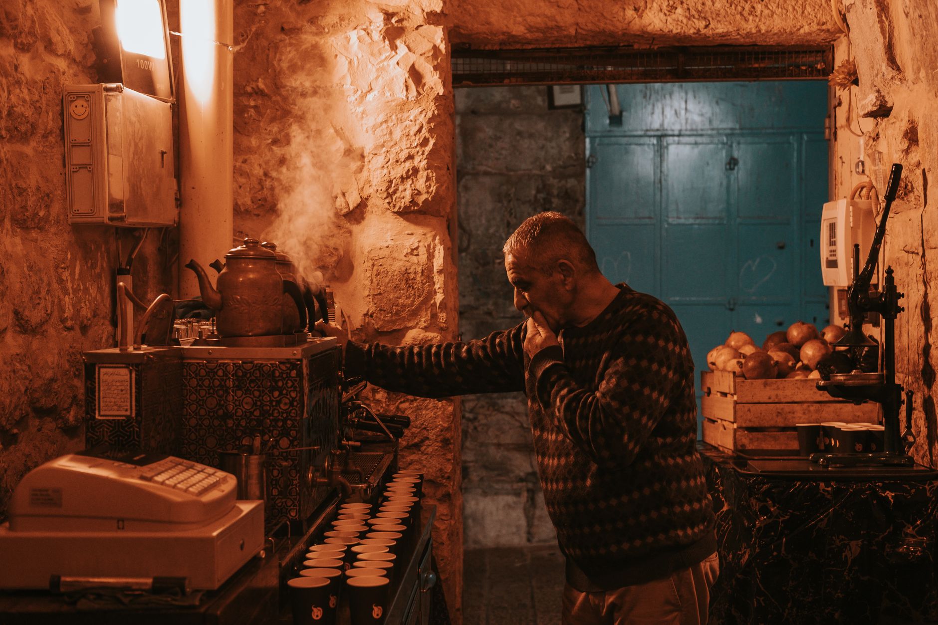 A man is standing in a small room with a coffee maker