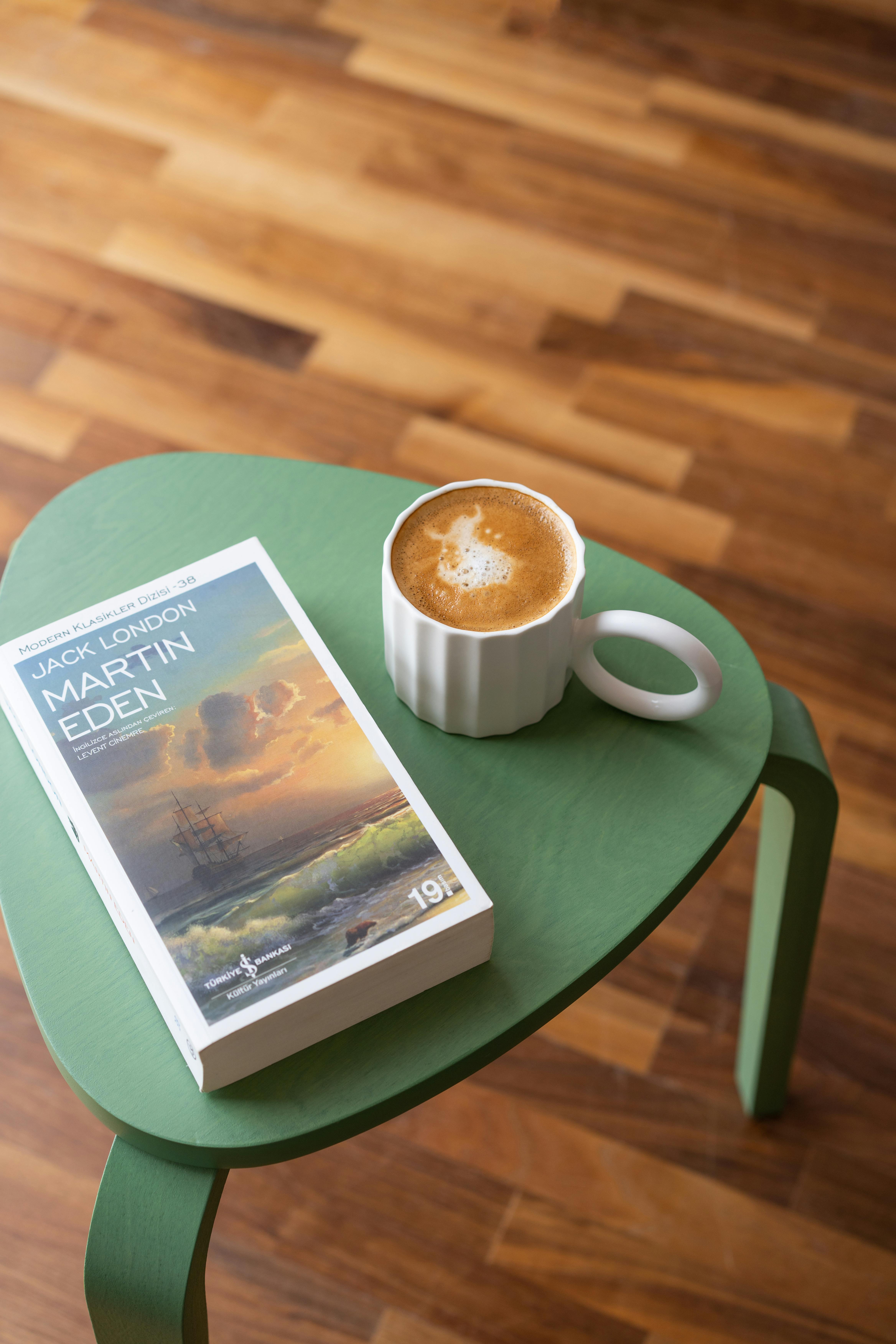 A cozy setup with a book and coffee on a stylish wooden table.