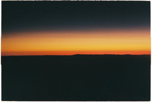 A stunning sunset silhouette with vibrant yellow sky and dark horizon.