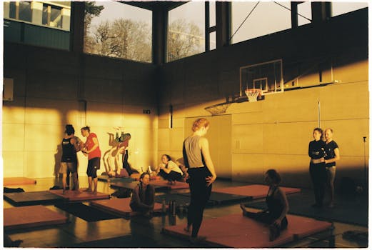 A dynamic group session in a sunlit Zürich gym featuring diverse activities and interactions.