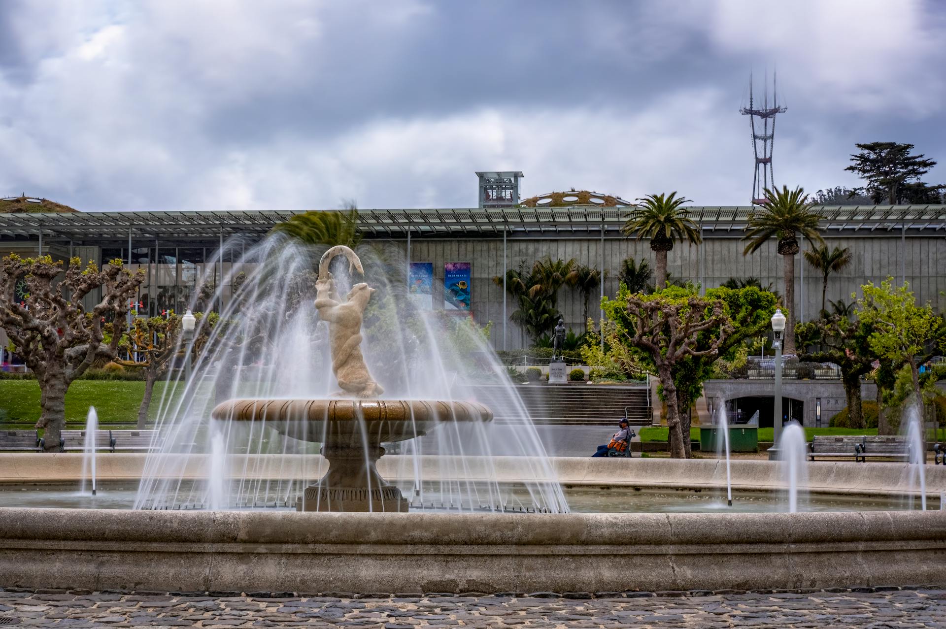 Serene view of a fountain in Golden Gate Park with Sutro Tower in the background.