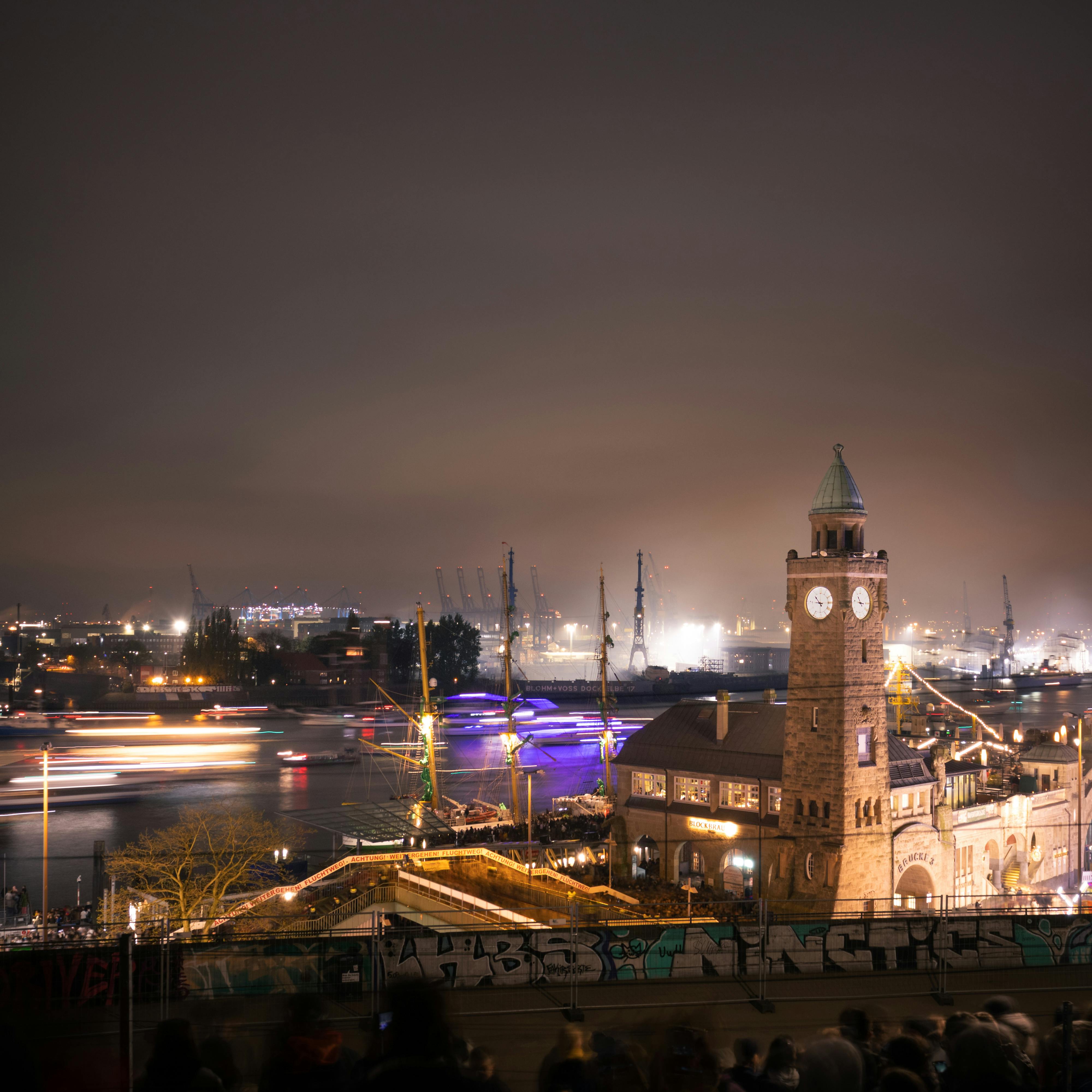 Stunning night view of Landungsbrücken in Hamburg showcasing the lively harbor and iconic clock tower.
