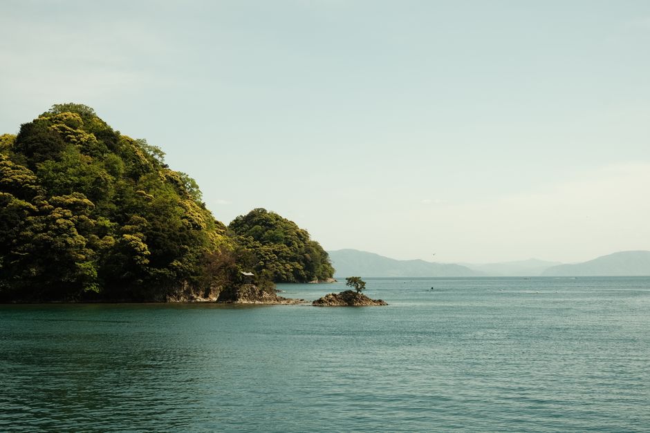 Explore the serene beauty of Ine Bay, surrounded by lush green trees and tranquil sea waters.