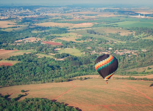 Aerial View of a Hot Air Balloon Flying over a Hill