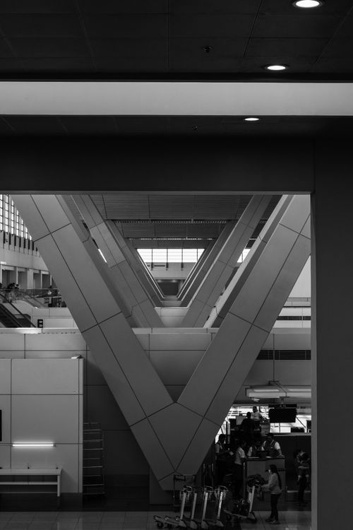 Free Black and white photo showcasing the symmetry and modern architecture of an airport terminal in Pasay, Philippines. Stock Photo