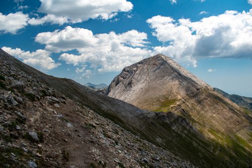 Free Scenic view of rocky mountain peak under blue sky with clouds in Bansko, Bulgaria. Stock Photo