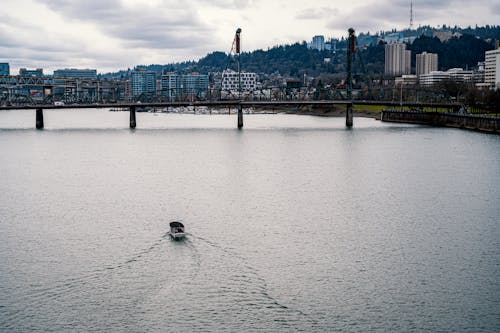 Motorboat on River with Bridge behind