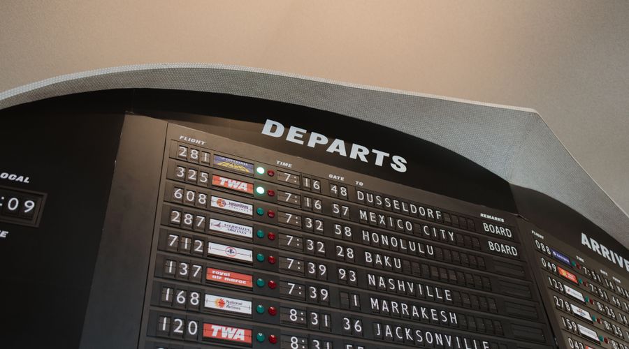 Passengers with luggage at a departure gate inside a major US international airport terminal before a long-haul flight to the Middle East