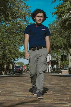 Man walking confidently through an urban setting, capturing a casual fashion style.