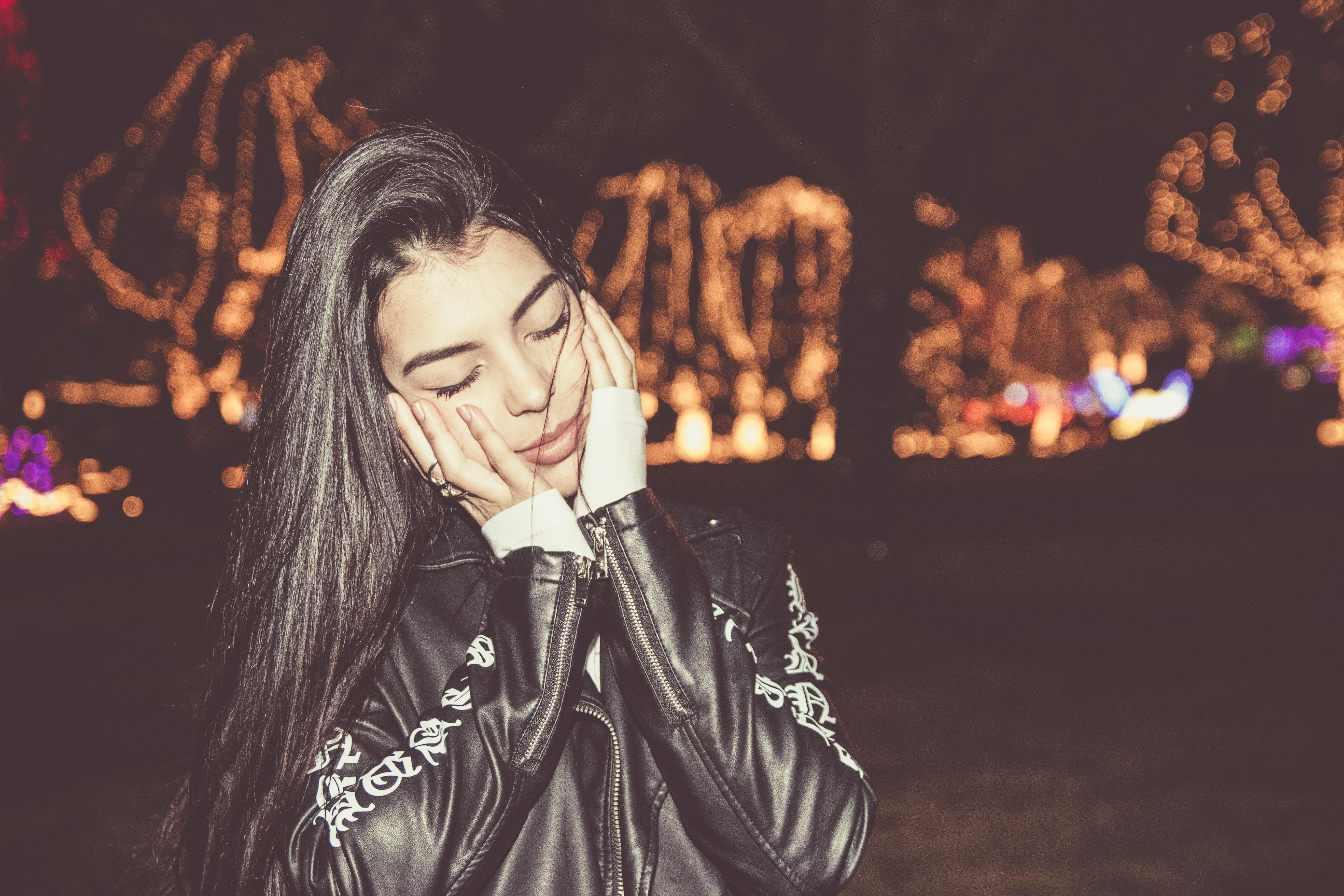 这幅肖像画描绘了一位女子在节日灯光下享受户外宁静夜晚的场景，画面十分安详