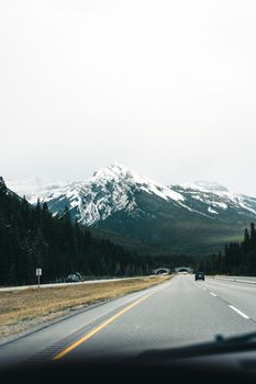 Experience a breathtaking journey through Canada with snow-capped mountains and lush forests.