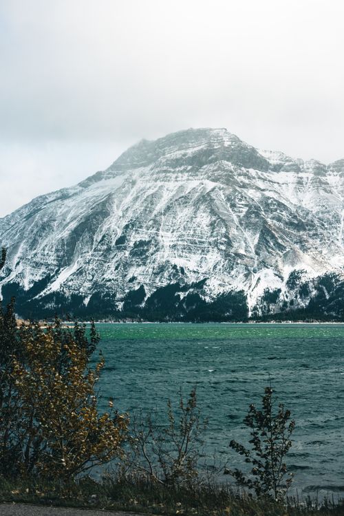 Free Breathtaking view of a snow-covered mountain reflecting in Waterton Lake, Alberta. Stock Photo