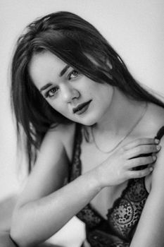 Captivating black and white portrait of a woman posing in lingerie, exuding elegance and style.