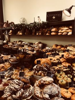 A wide array of fresh breads and sweet pastries on display in a cozy market setting.