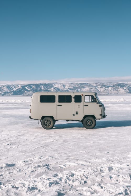 Free Vintage van on a vast snowy landscape with mountains in Baykalsk, Russia. Stock Photo