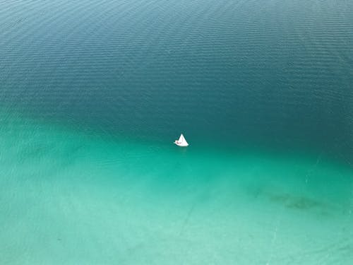 Aerial View of a Sailboat on Turquoise Water 