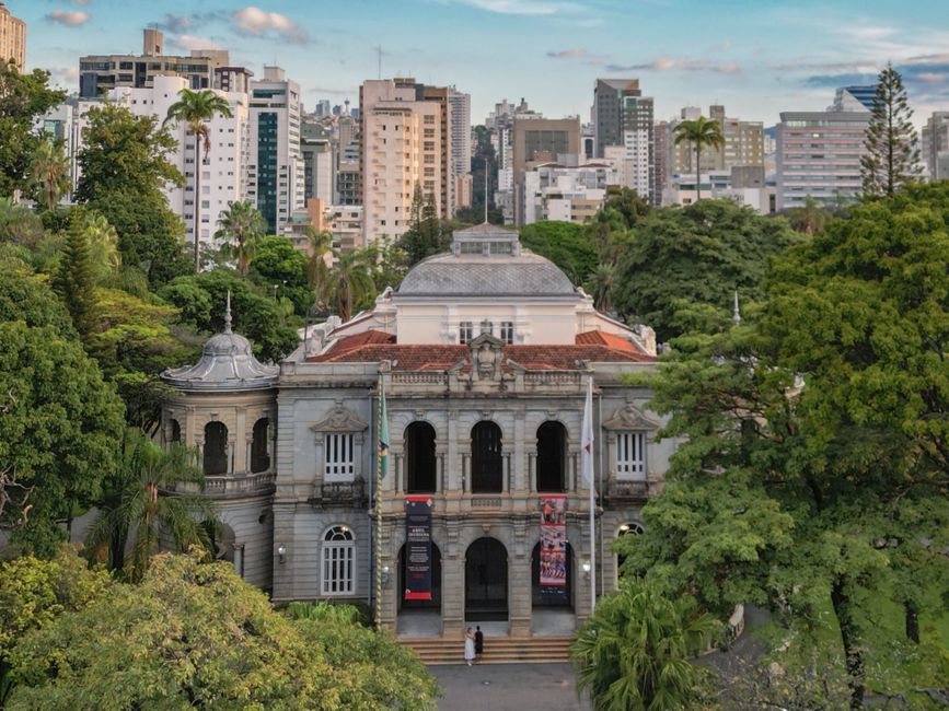 Como a Criatividade Pode Melhorar seu Estilo de Vida Sustentável 2 Elegant view of the Palace of Liberty surrounded by lush trees and modern skyline in Belo Horizonte, Brazil.