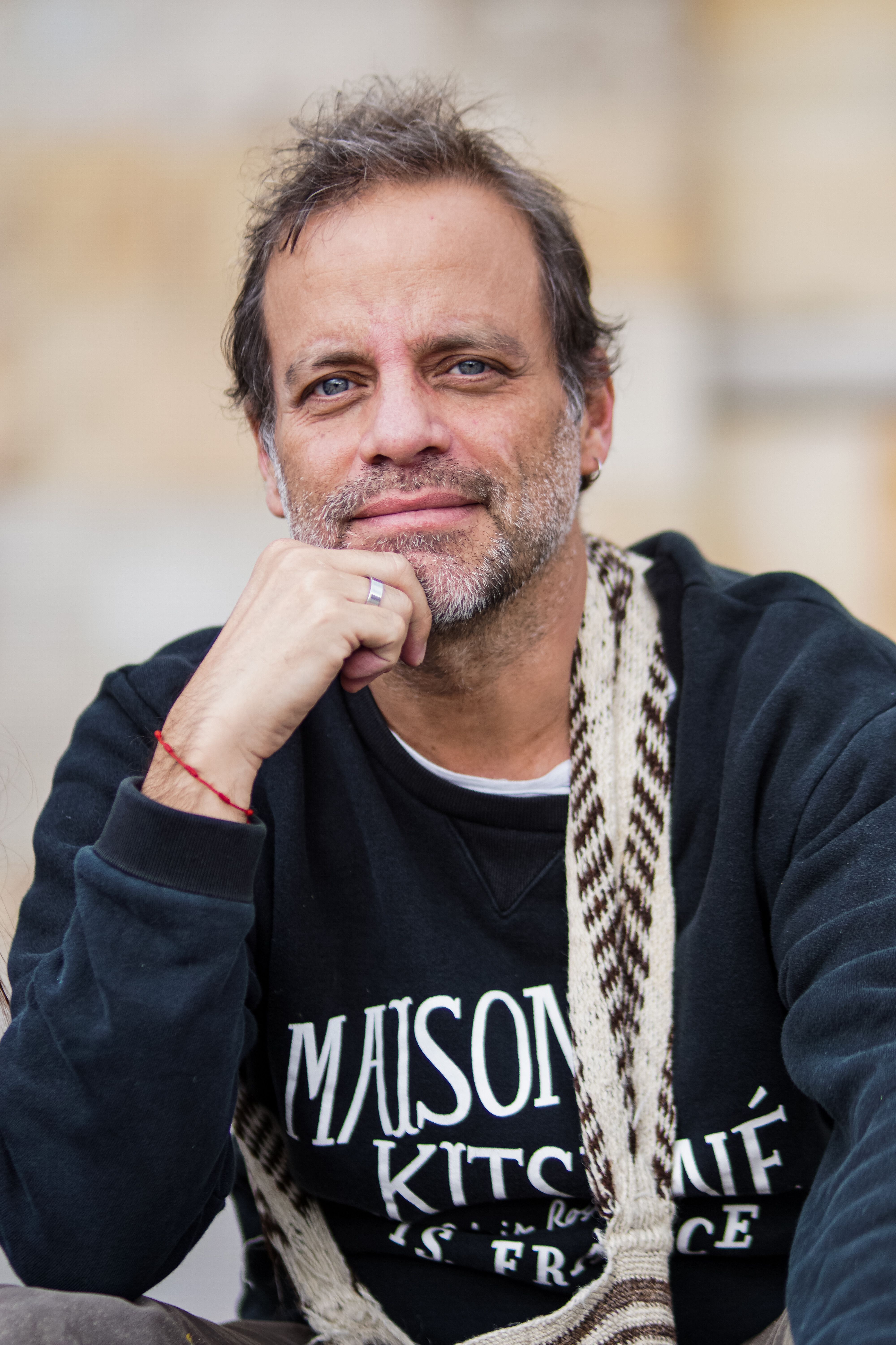 Portrait of a mature man with gray stubble, smiling outdoors in Bogotá.