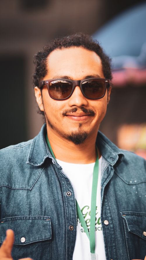 Free Casual portrait of a man in sunglasses and denim shirt, outdoors in bright sunlight. Stock Photo