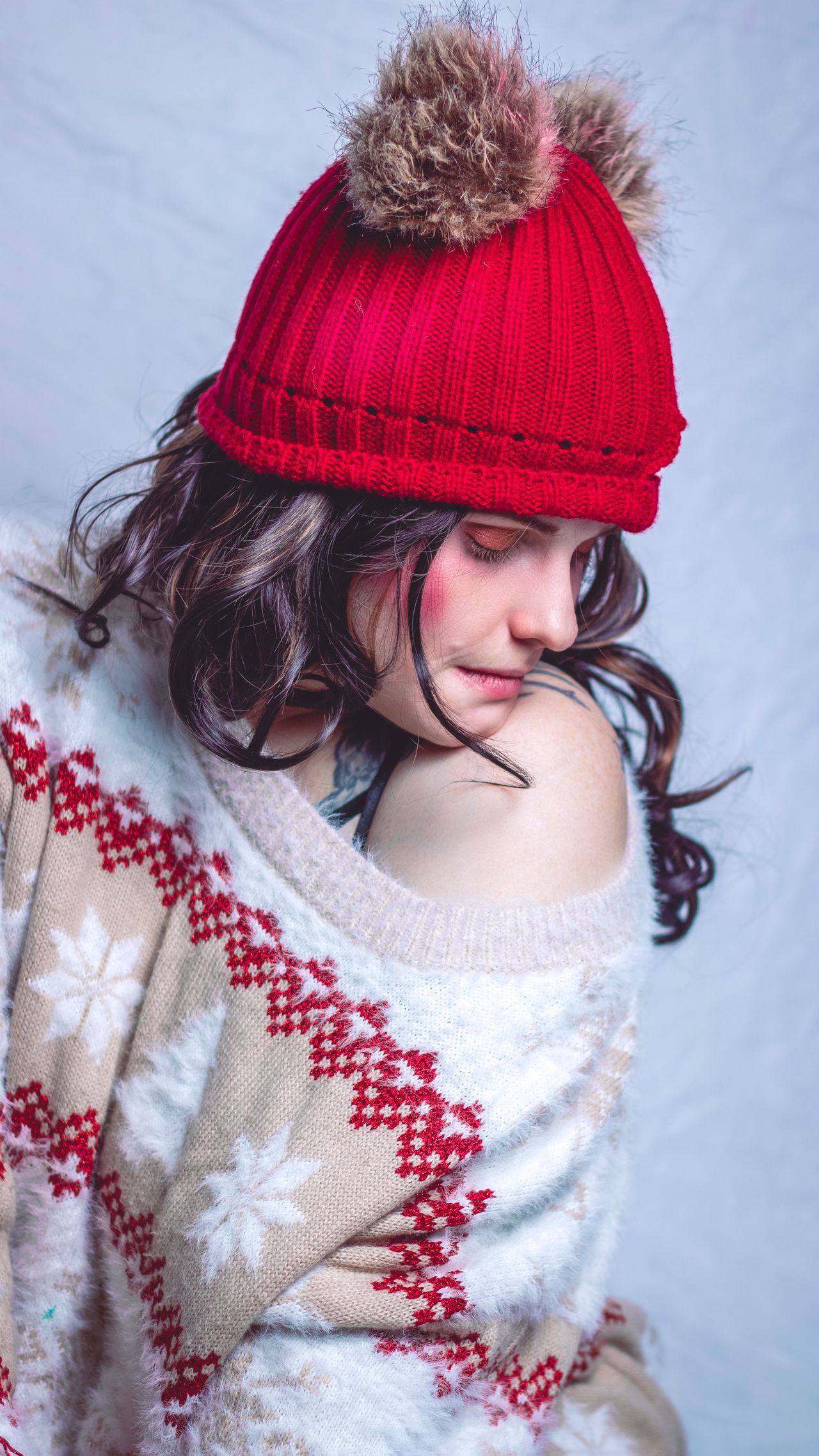 Woman in a red knit beanie and fair-isle knit sweater