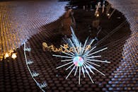 潮湿水坑的纹理表面捕捉到了圣诞灯和装饰品的生动倒影