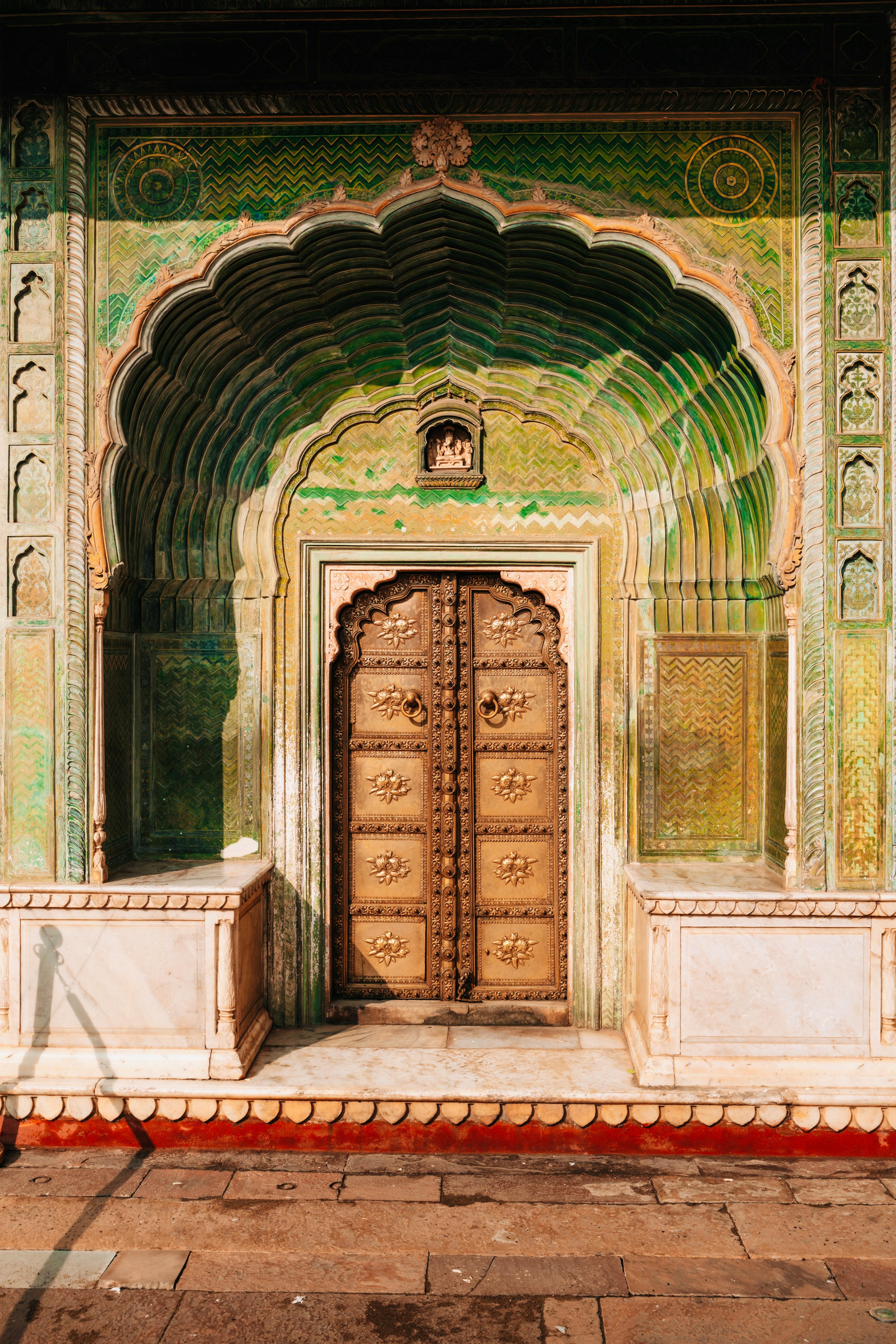 Detailed view of the ornate green gate at the City Palace, Jaipur, showcasing intricate Indian craftsmanship.