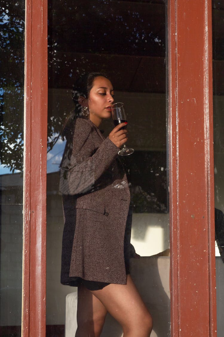 Woman Drinking Red Wine Near The Window