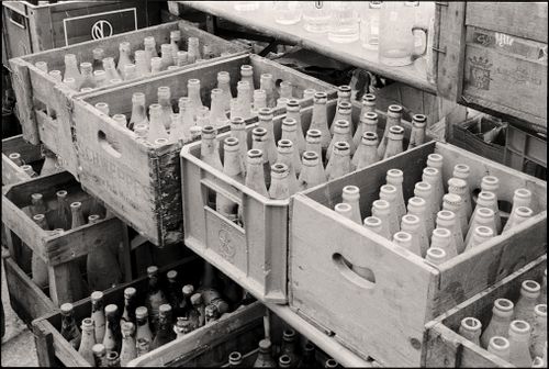Free Black and white photo of vintage glass bottles stored in wooden crates, reflecting a retro vibe. Stock Photo