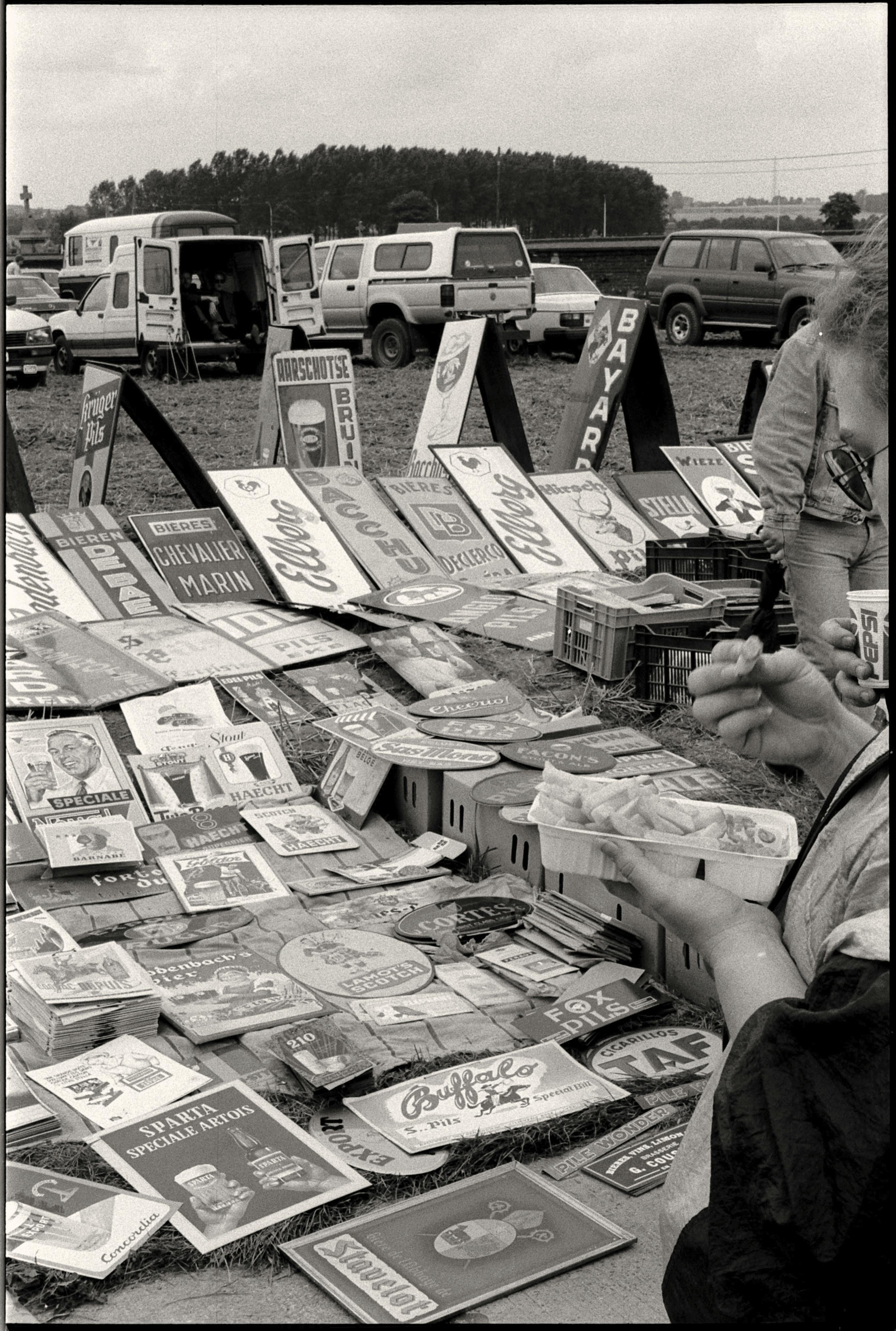 Black and white photo of a market stall displaying vintage retro advertisements.
