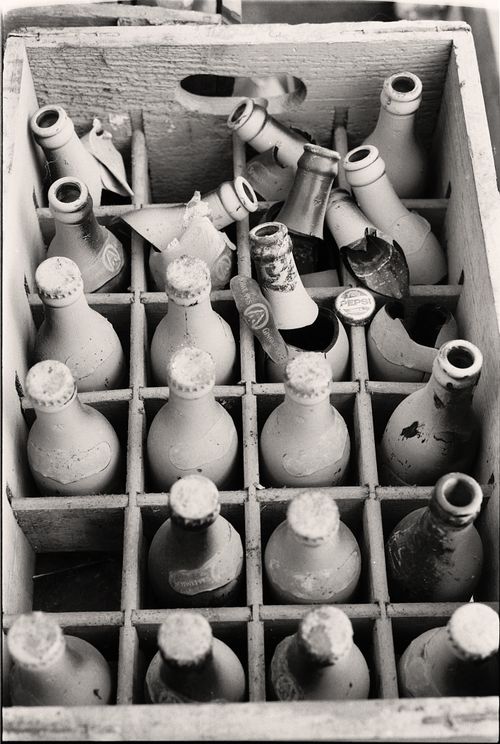 Free Black and white photo of dusty, broken bottles in an old wooden crate, exuding a vintage and still life aura. Stock Photo