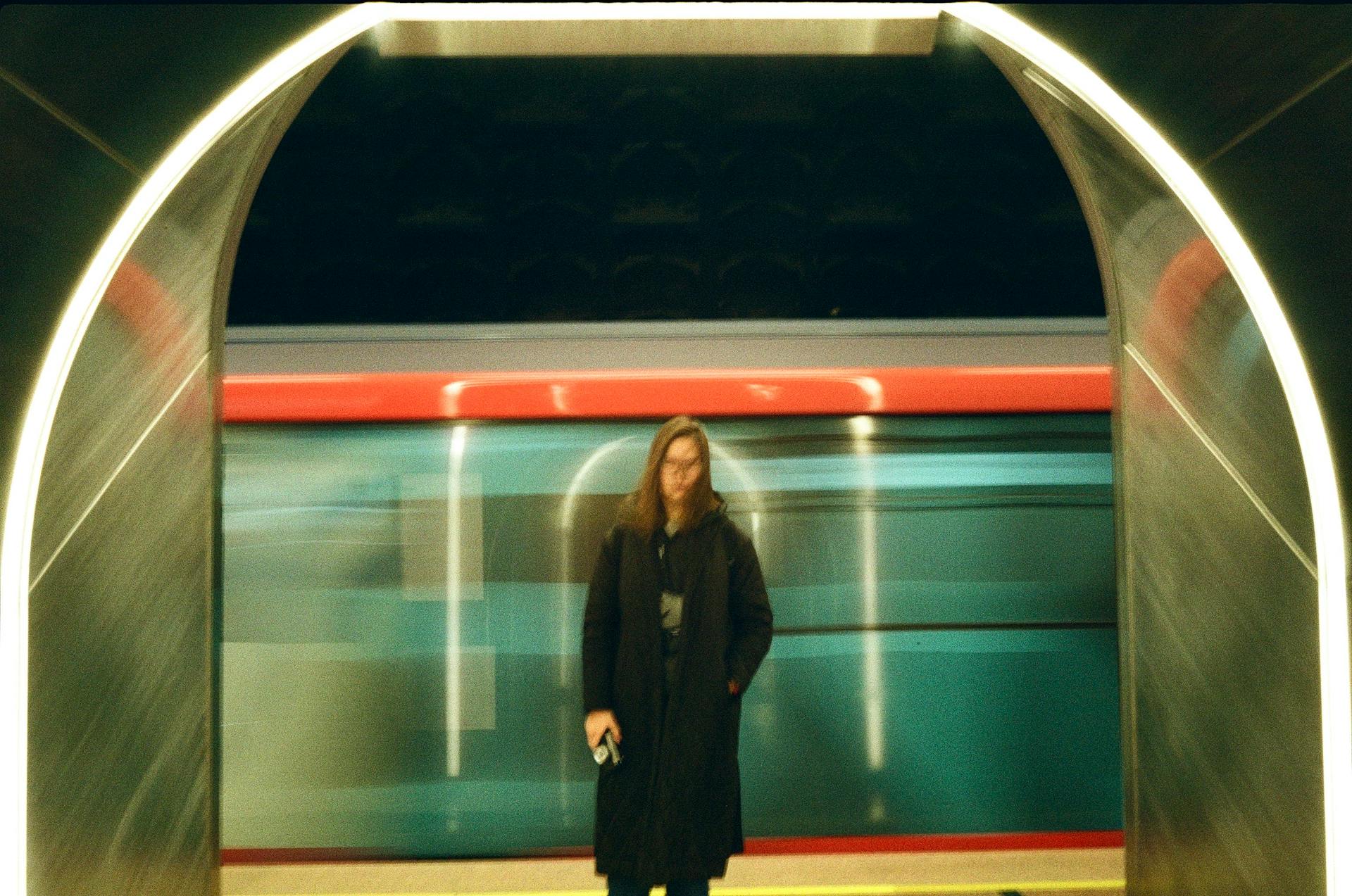 Blurry Picture of a Woman on the Station and a Train Passing behind Her