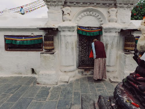 Elderly Woman in front of the Boudhanath Stupa in Kathmandu, Nepal 