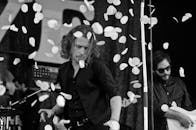 舞台上，充满活力的音乐家在黑白照片中与落下的花瓣一同表演