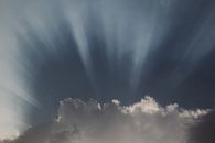 Dramatic sunbeams penetrate through clouds, creating a captivating sky scene.