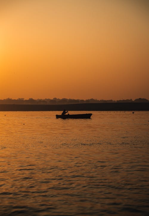 Person on Boat on River at Sunset