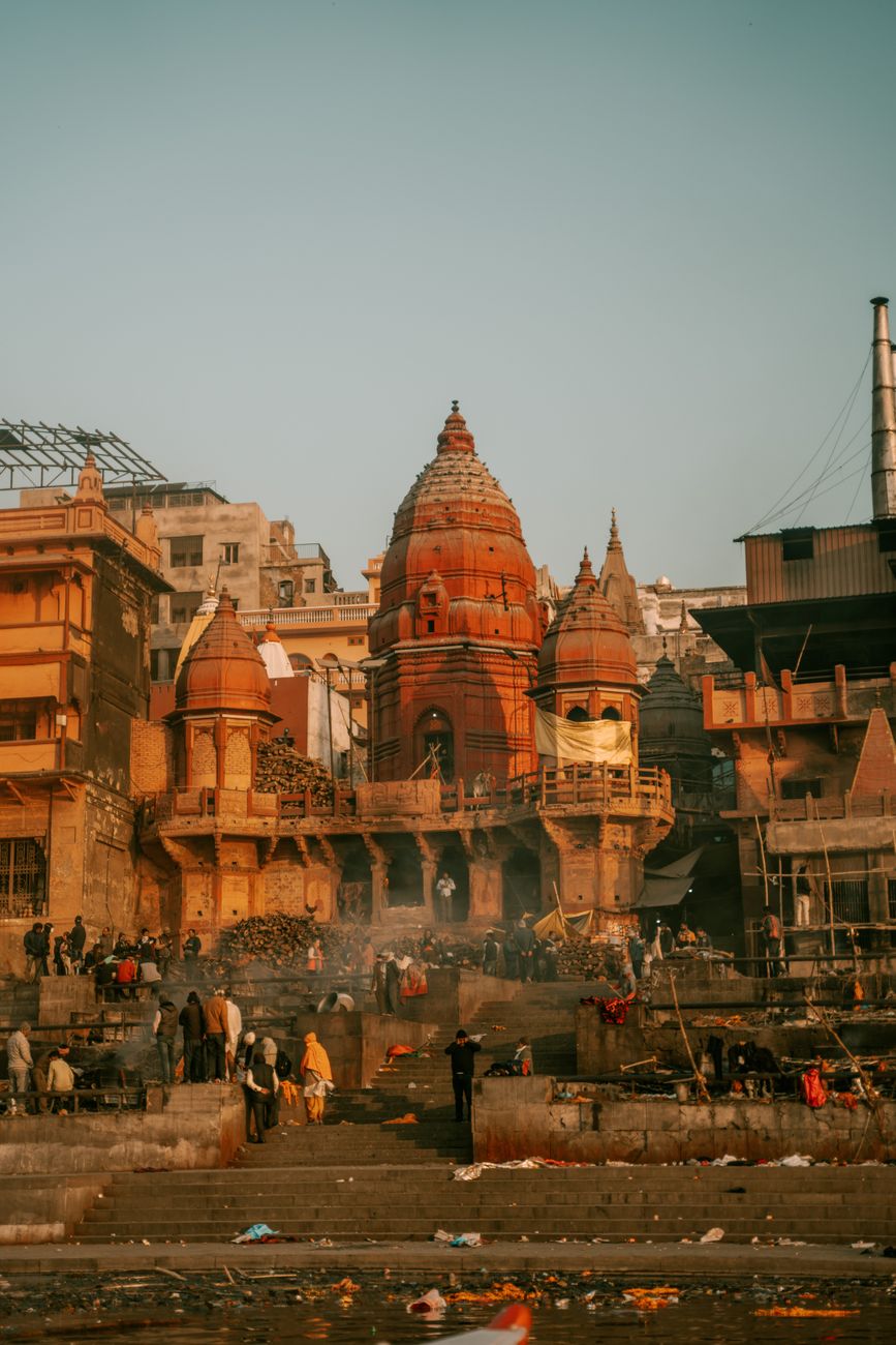 Sunrise over temple ghats with calm water reflections