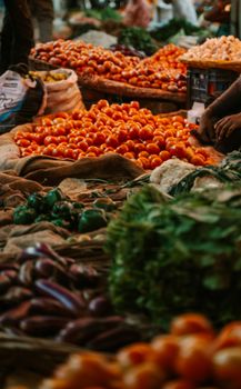 Lively street market scene in India with piles of fresh vegetables and fruits on display.