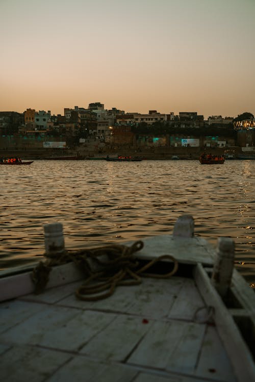 Wooden Boat on River in Town at Sunset