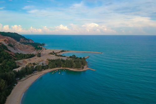Free Aerial view of a stunning seascape with clear blue water, sandy beach, and lush greenery. Stock Photo