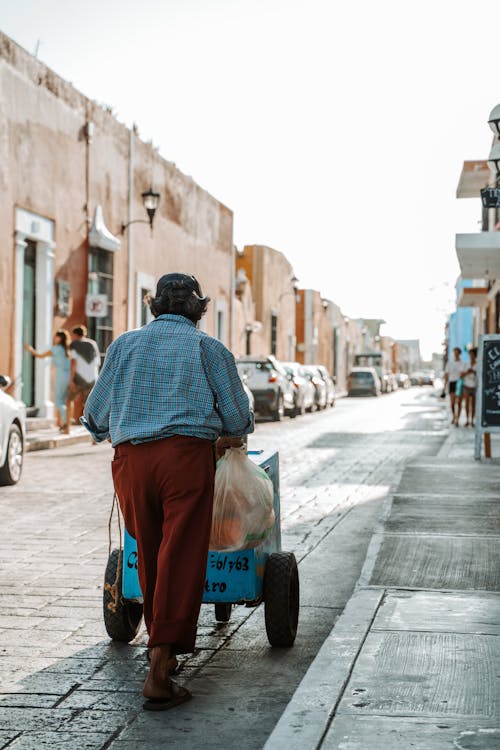 Man Pushing a Cart in a Town Street 