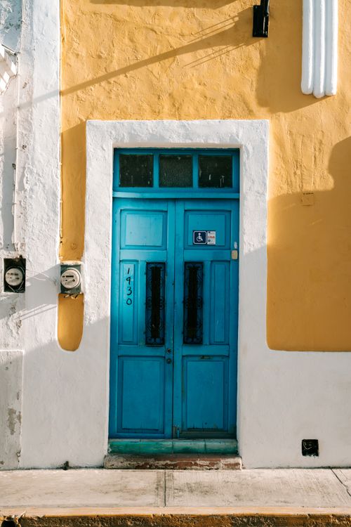 Free Colorful blue door on a sunny yellow facade, capturing Mexican architectural charm. Stock Photo