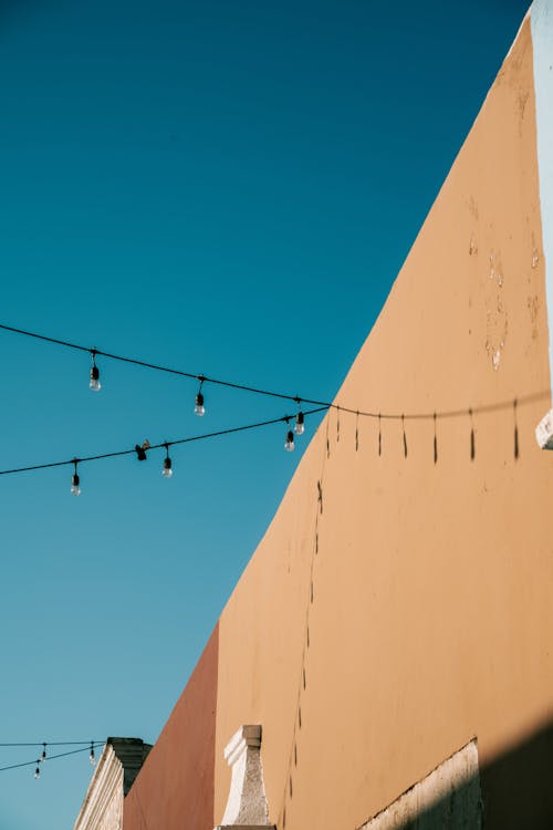 Low Angle Shot of String Lights Hanging between Buildings 