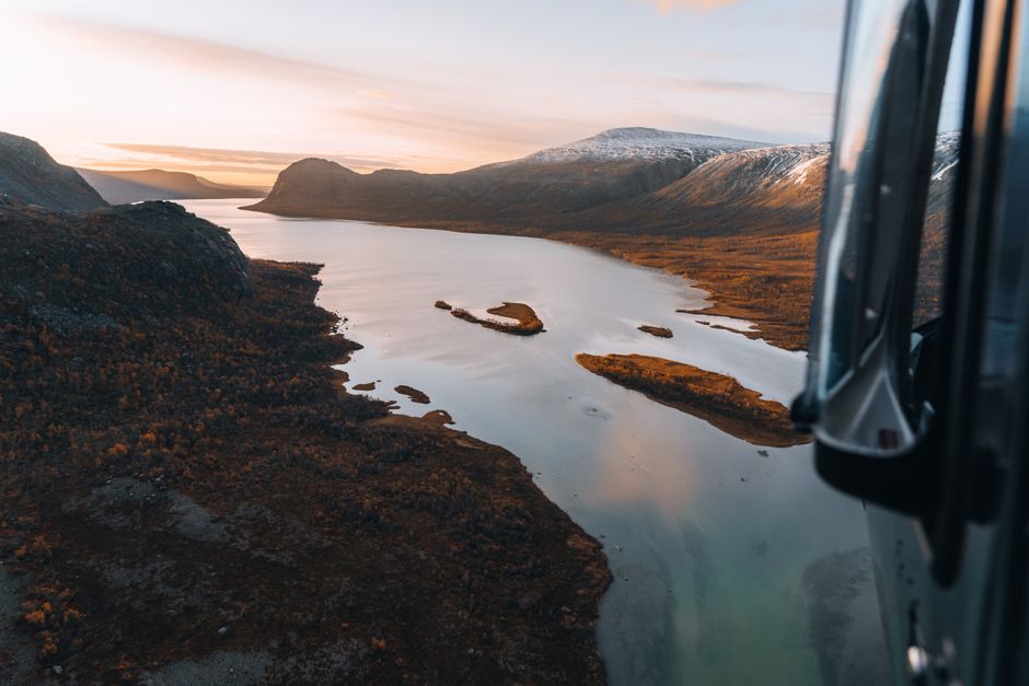 Spectacular Helicopter and Fjords Sightseeing from Haugesund Review: Norway's Most Exclusive Aerial Adventure Review 2026 - Captivating aerial photograph of a tranquil river valley flanked by rugged hills at sunset.