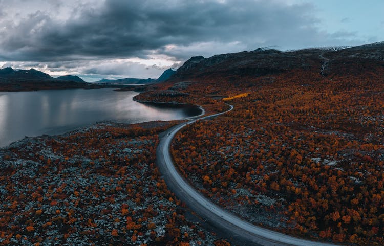 Clouds Over Road Near Lake In Autumn